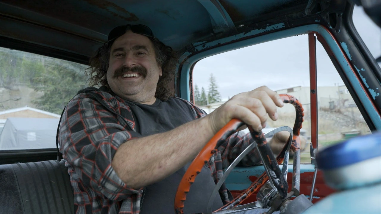 Avery Shoaf smiling while driving a vintage vehicle, documentary-style photo from Rust Valley Restorers.