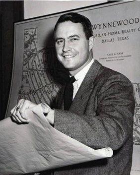 Angus G. Wynne in a black-and-white portrait holding a large rolled map or blueprint, standing in front of a Wynnewood d