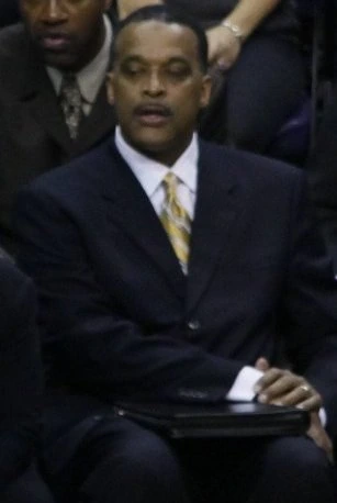 Randy Ayers seated in a suit at a basketball game