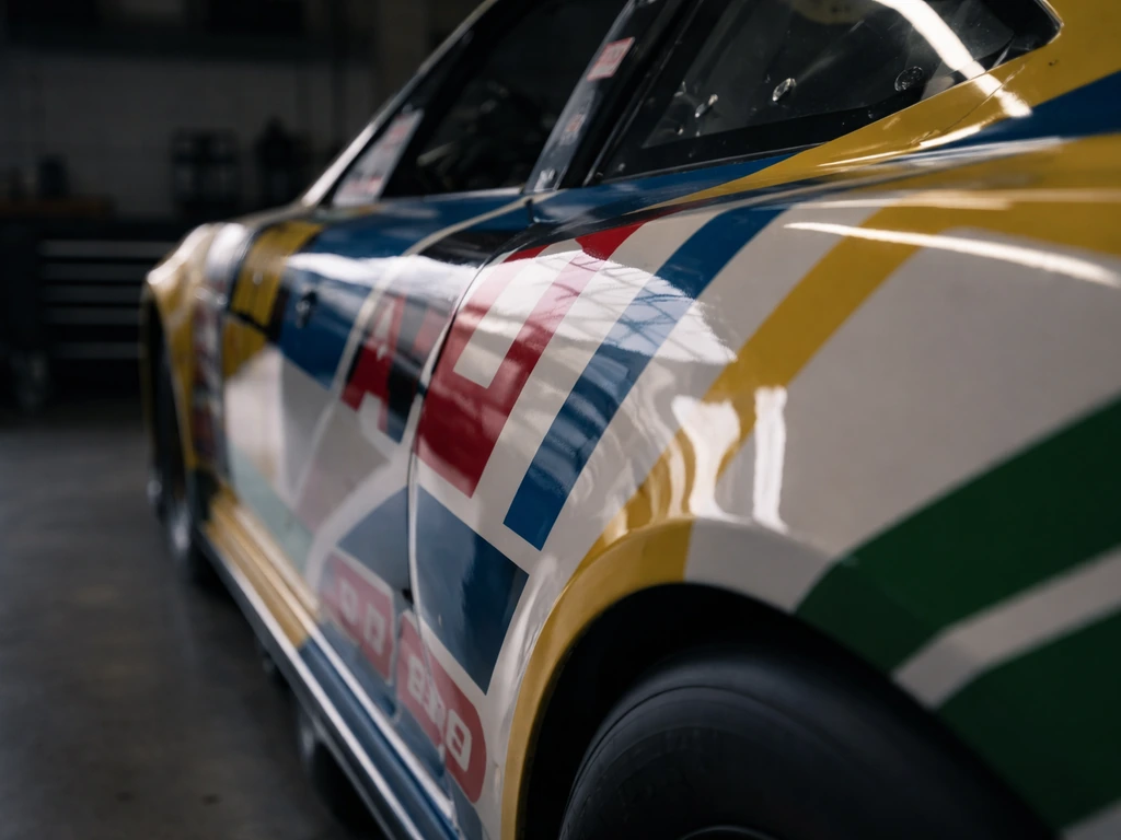 Close-up of sponsor decals on a parked NASCAR race car in a quiet garage bay.