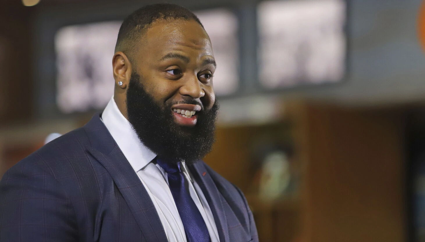 Akiem Hicks smiling in a suit